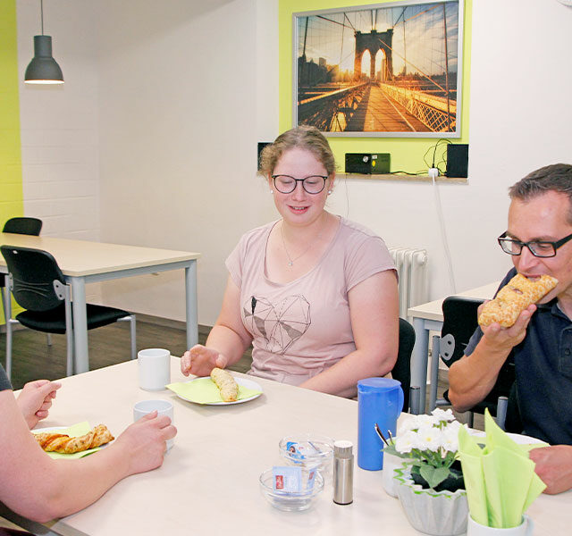 drei Personen essen in der Mensa