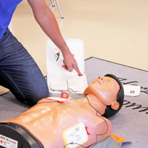 Der Defibrillator wird an einer Puppe anschaulich erklärt