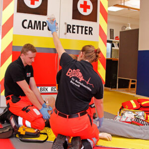 Rettungssanitäter in einer Szene in RETTcampus vor einem Rettungswagen